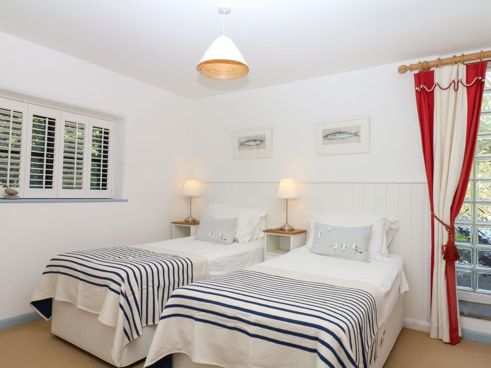 A bedroom with two twin beds and a lamp at Burrows in Venn Ottery near Sidmouth