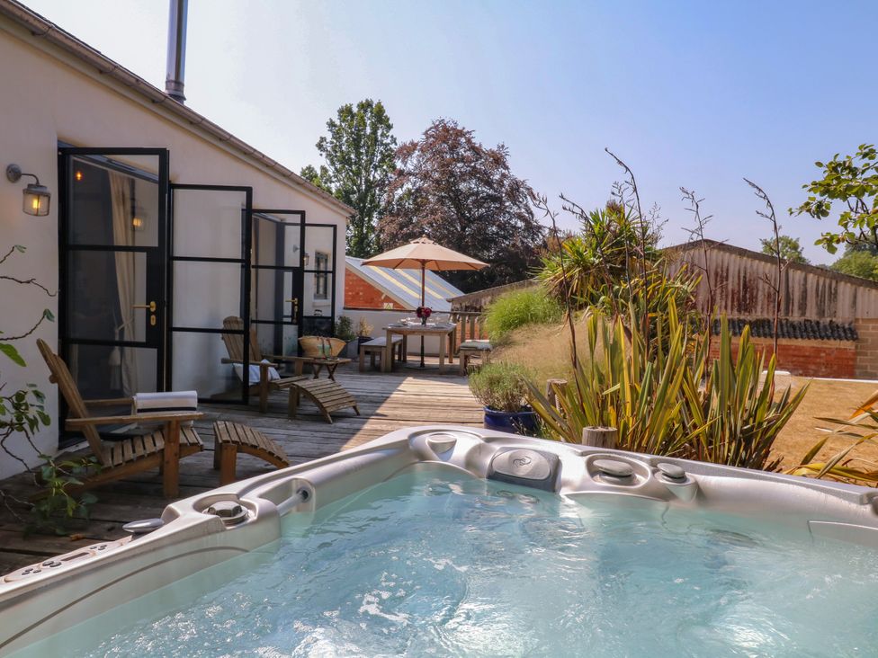 An outdoor area with a hot tub and seating at Burrows in Venn Ottery near Sidmouth