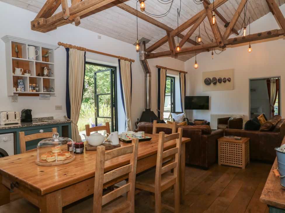 A kitchen with a dining table and chairs at Burrows in Venn Ottery near Sidmouth