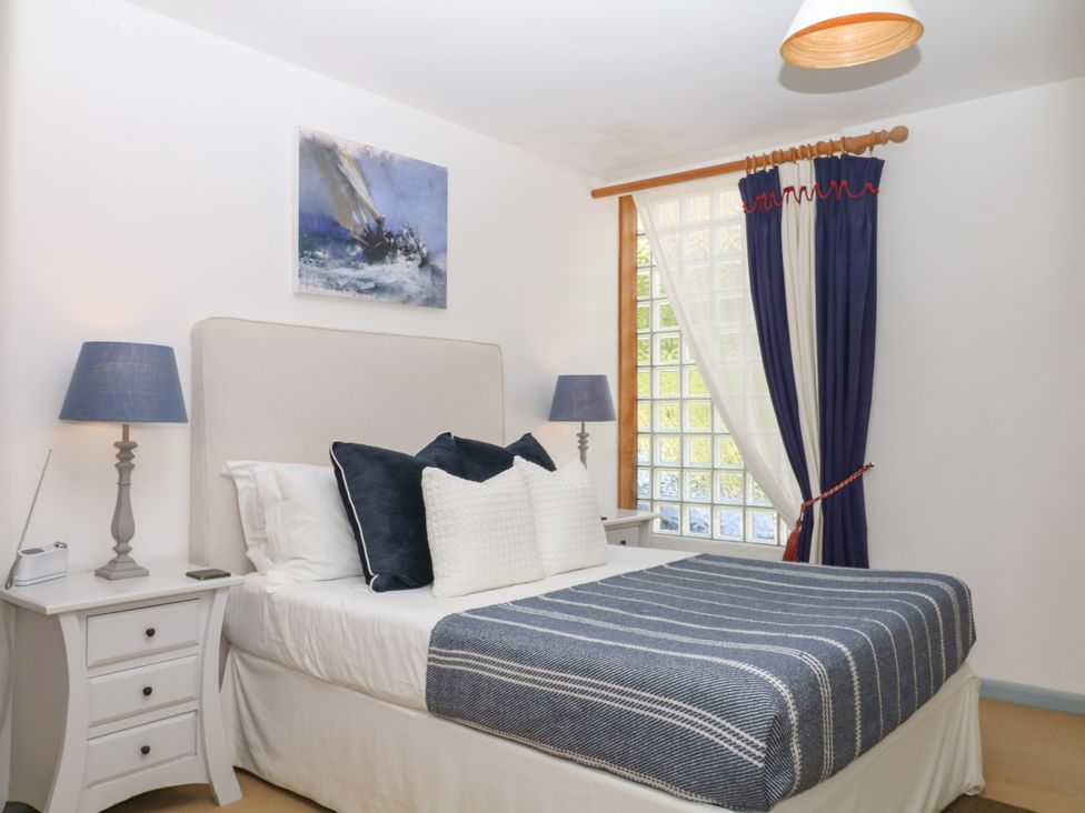 A bedroom with a bed and bedside table at Burrows in Venn Ottery near Sidmouth