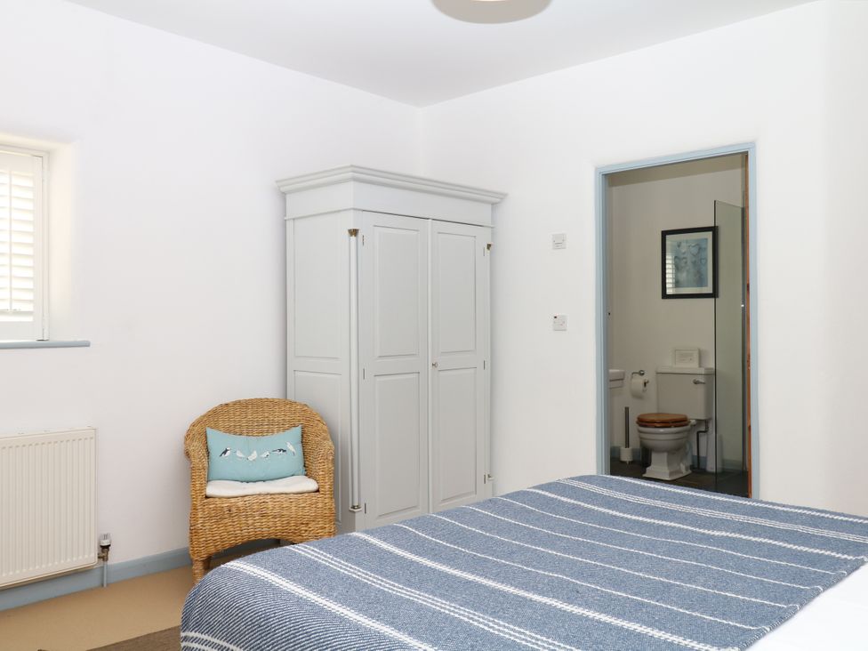 A bedroom with a bed and wardrobe at Burrows in Venn Ottery near Sidmouth