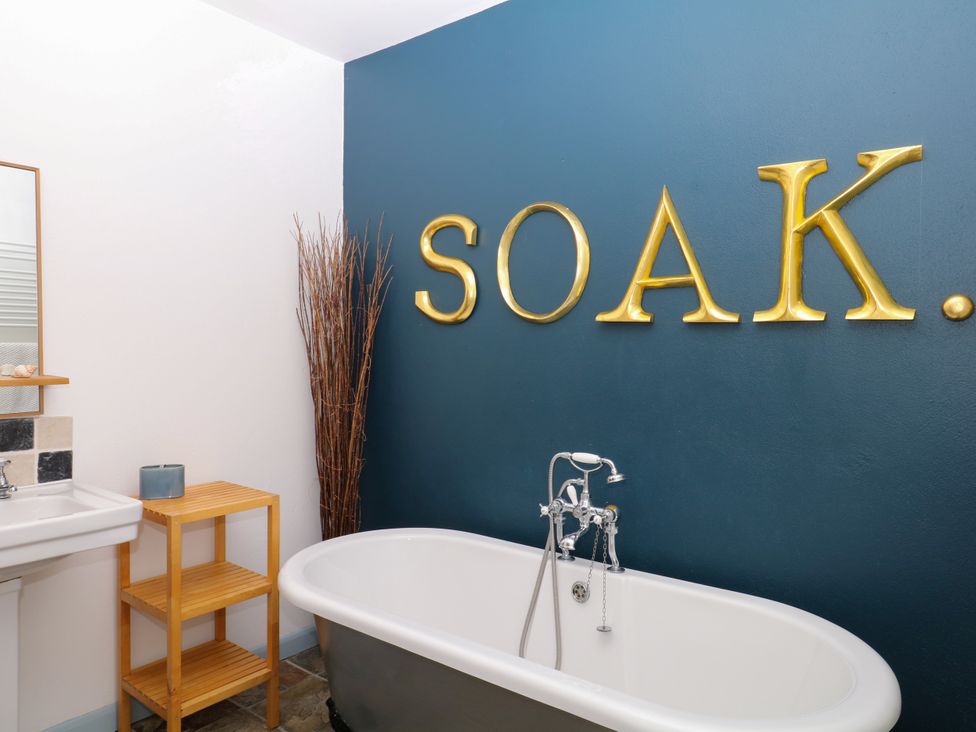 A bathroom featuring a bathtub and sink at Burrows in Venn Ottery near Sidmouth