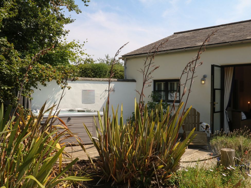 A garden with a hot tub and bench at Burrows in Venn Ottery near Sidmouth