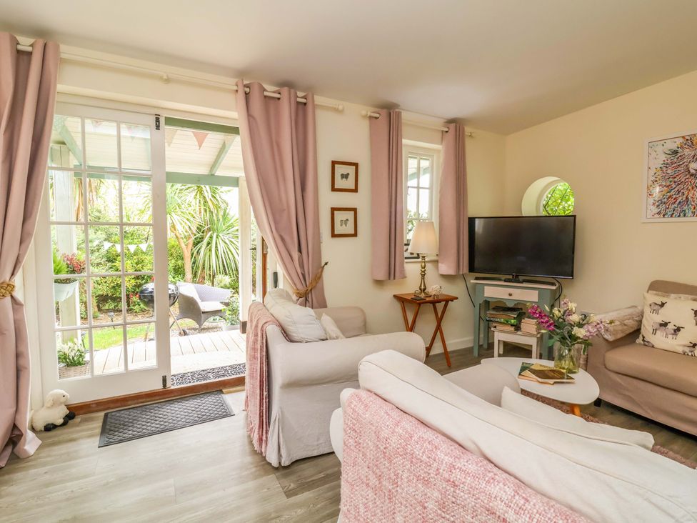 A living room with a sofa and a television at Sunset Cottage Swimbridge near Barnstaple