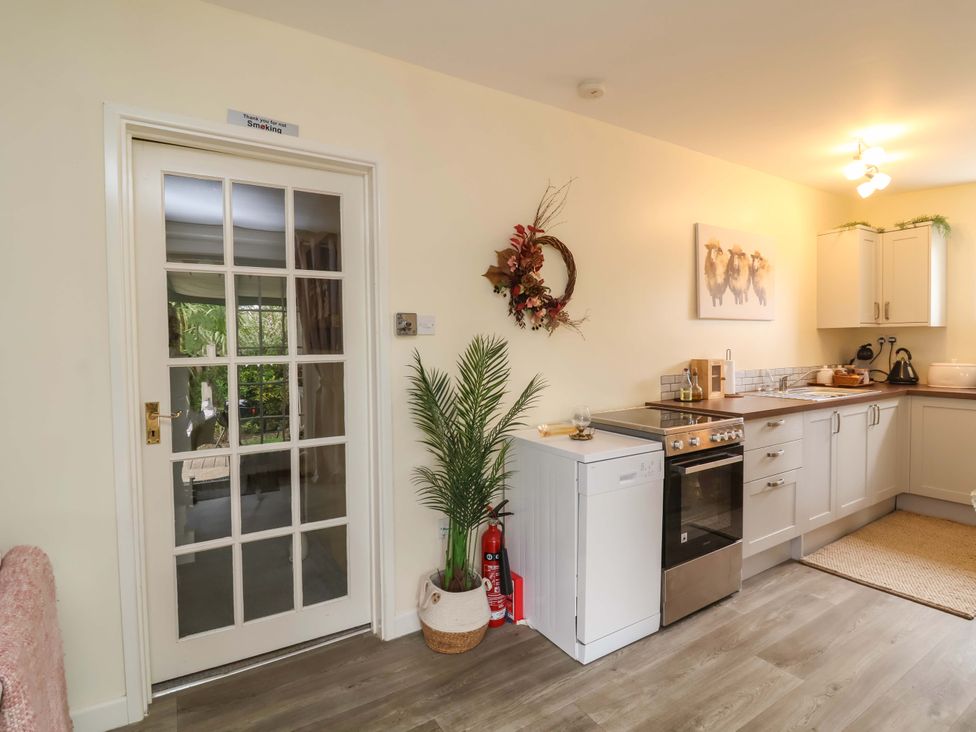 A kitchen with stove and cabinetry at Sunset Cottage in Swimbridge near Barnstaple