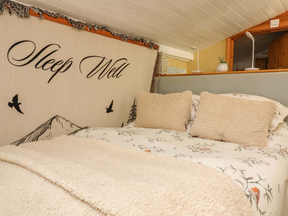 A bedroom with a bed and pillows at Sunset Cottage Swimbridge near Barnstaple