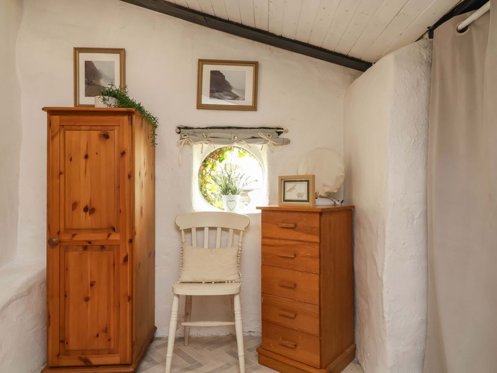 A bedroom with a wardrobe and dresser at Sunset Cottage Swimbridge near Barnstaple