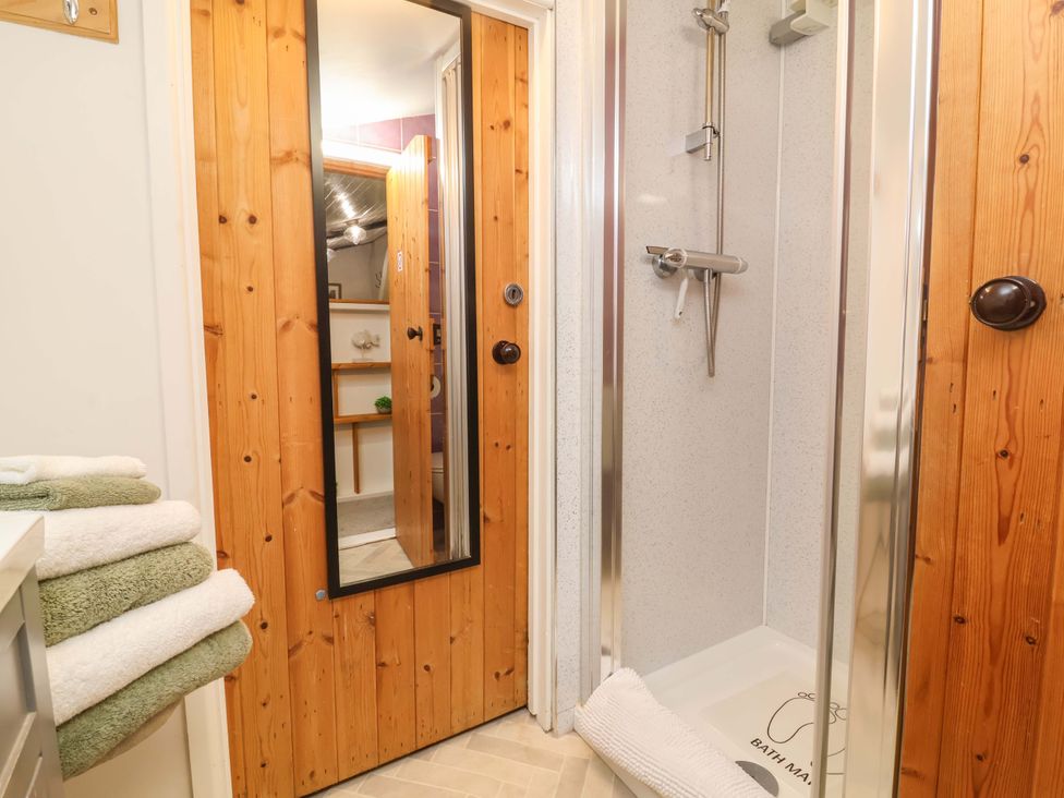 A bathroom with a shower and towels at Sunset Cottage Swimbridge near Barnstaple