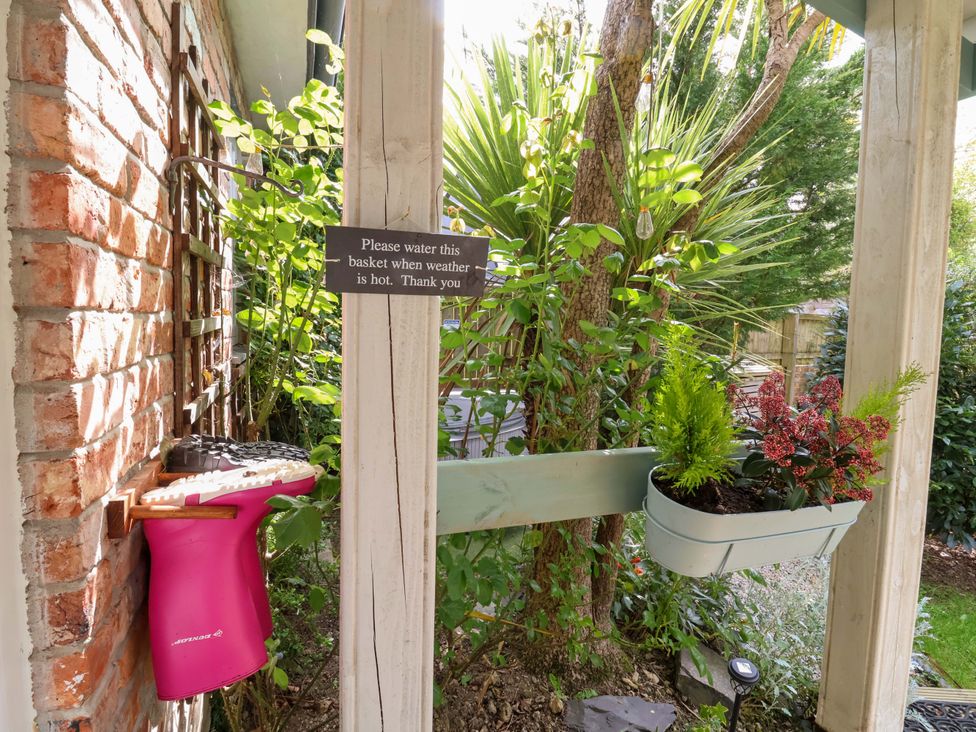 An outdoor area with plants and a sign at Sunset Cottage Swimbridge near Barnstaple