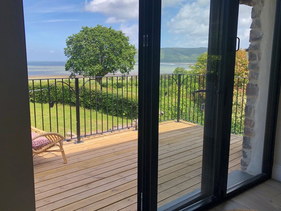 A balcony with a view of a tree and landscape at Worthy Barn in Porlock Weir