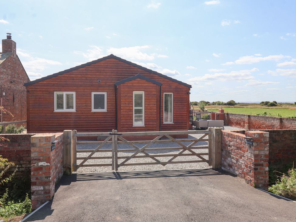A house with a gravel driveway and a gate at Waverley Cottage in Kilnsea near Easington, Hull