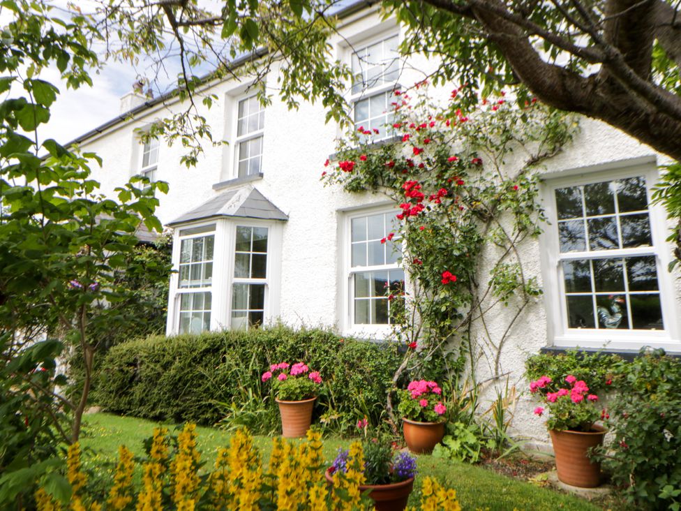 A house with flower pots and flowers at Pen y Graig in Aberporth