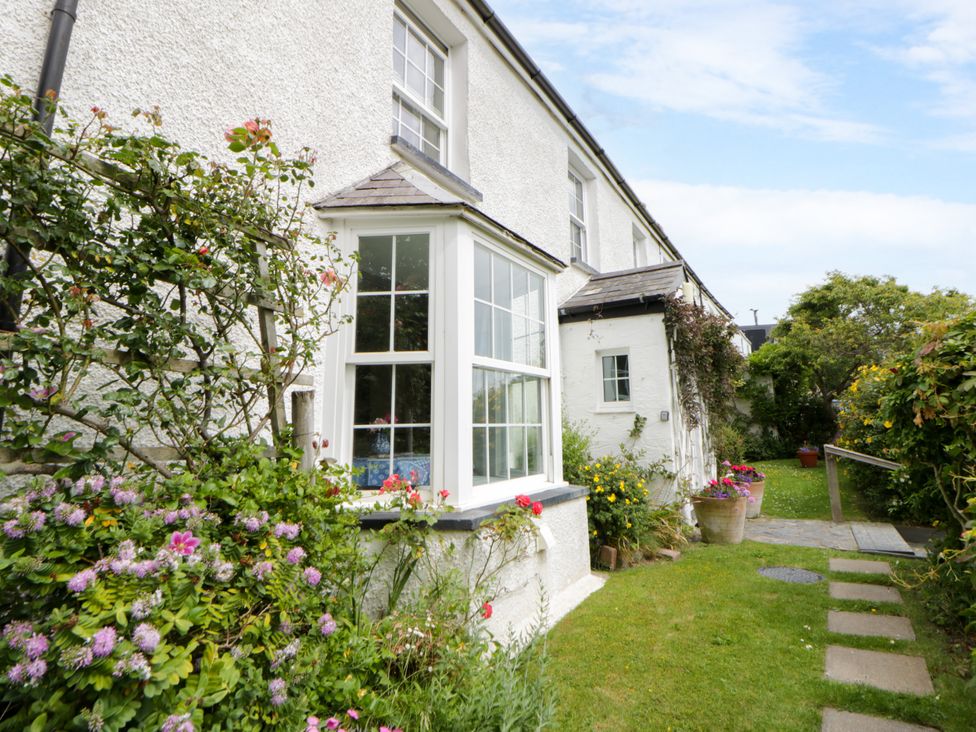 A garden with a window and pathway at Pen y Graig in Aberporth