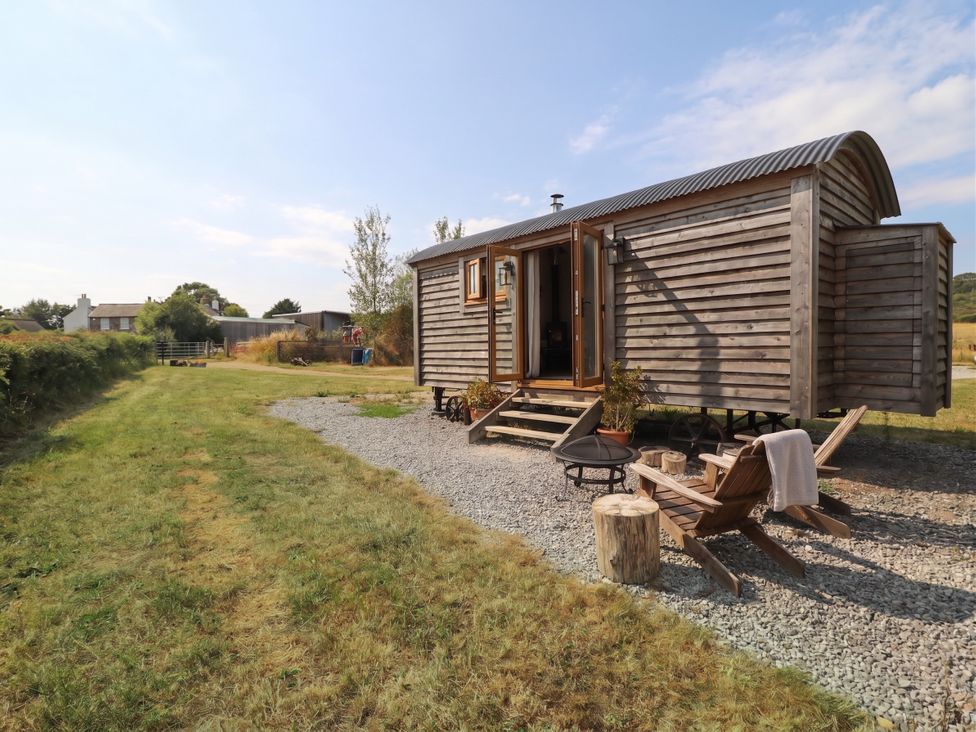A wooden cabin with outdoor seating at Cariad Mawr Gwaenysgor near Prestatyn