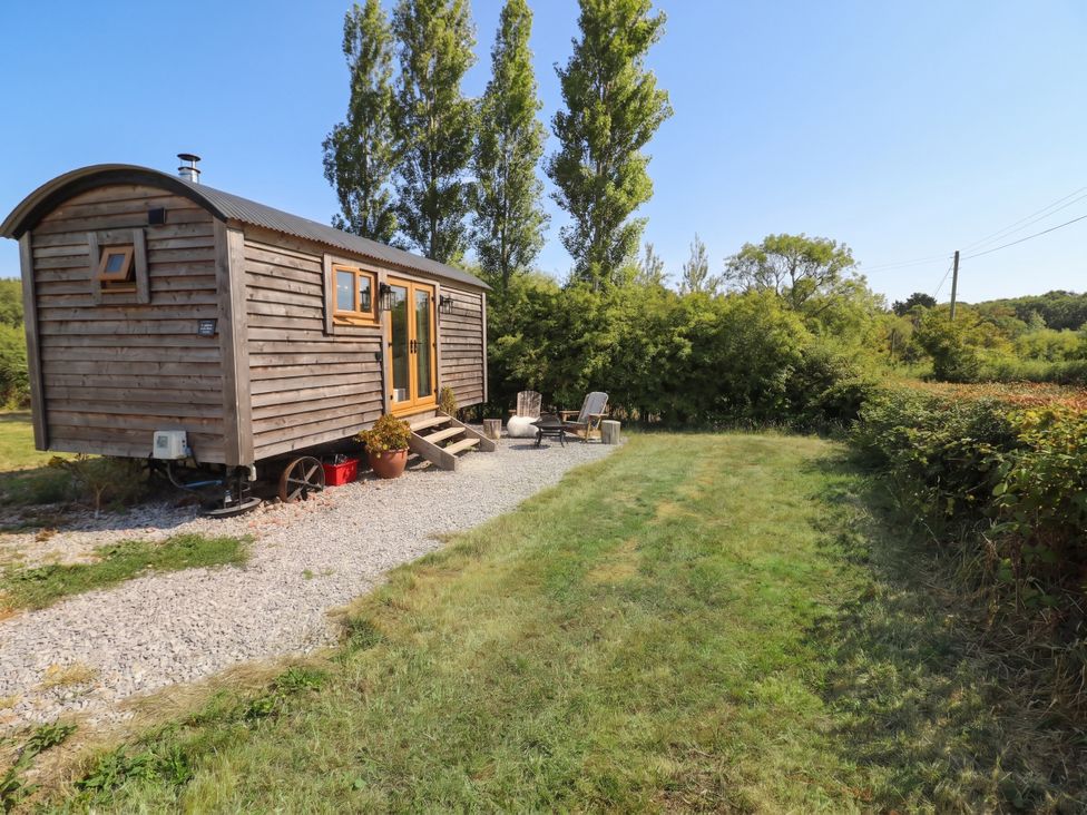 A tiny house with a gravel path and chairs in an outdoor space at Cariad Mawr Gwaenysgor near Prestatyn