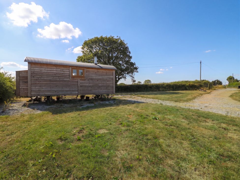 A wooden cabin near a gravel path at Cariad Mawr in Gwaenysgor near Prestatyn