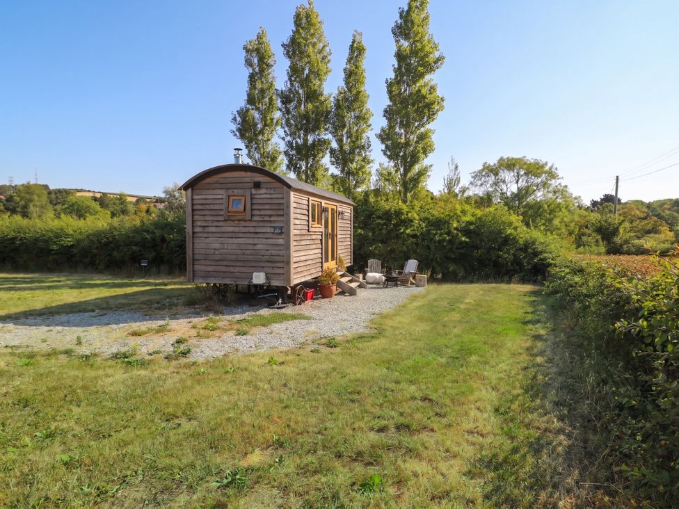 A tiny house with chairs on gravel at Cariad Mawr in Gwaenysgor near Prestatyn