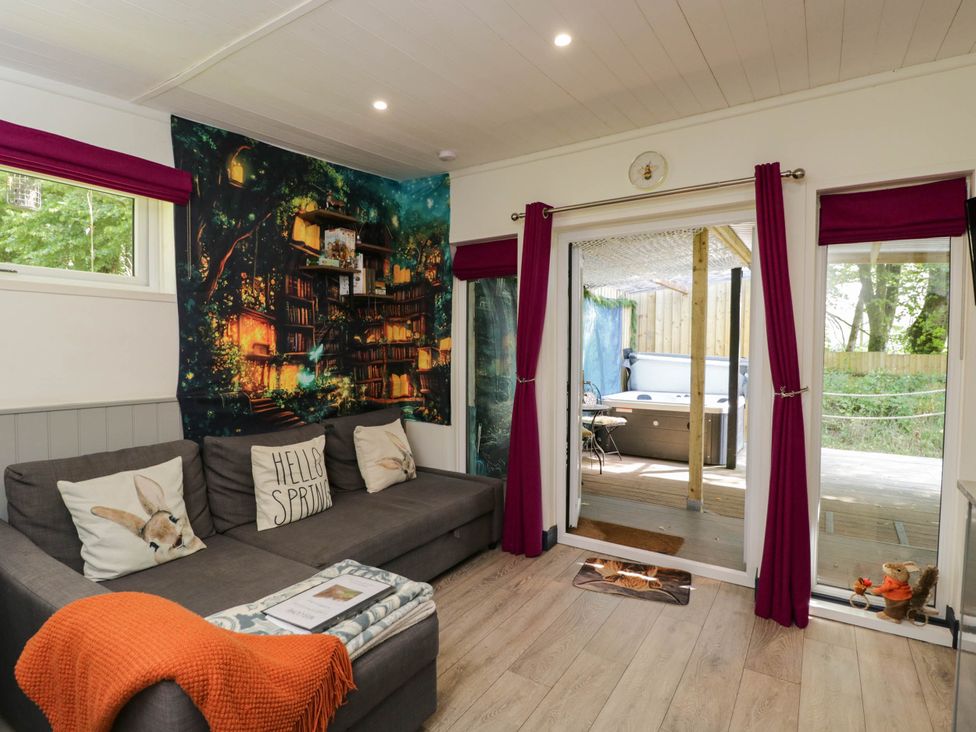 A living room with a sofa and wall mural at Squirrels Lodge in South Molton