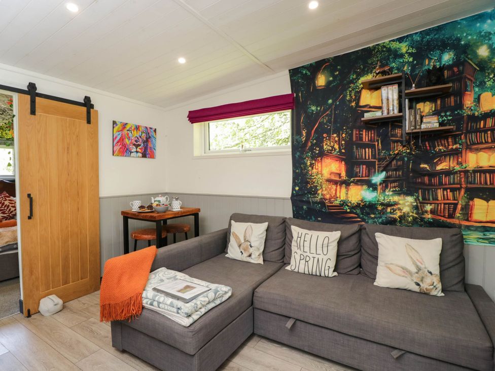 A snug with a sofa and wall art at Squirrels Lodge in South Molton