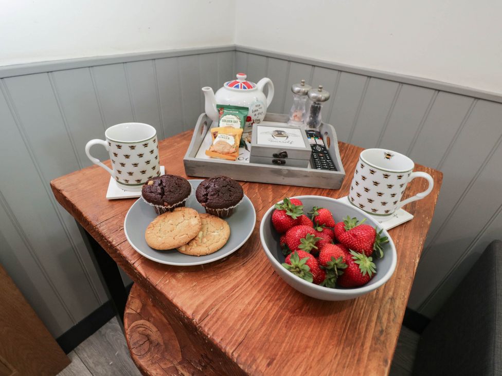 A table with cups, cookies, brownies, and strawberries at Squirrels Lodge in South Molton