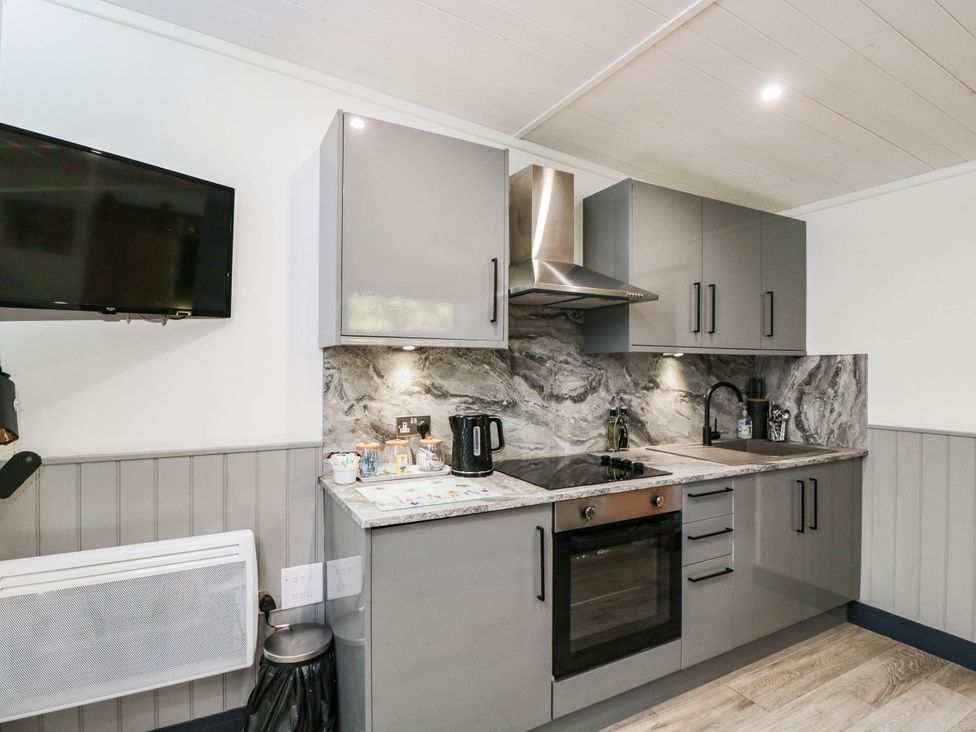 A kitchen with cabinets and appliances at Squirrels Lodge in South Molton