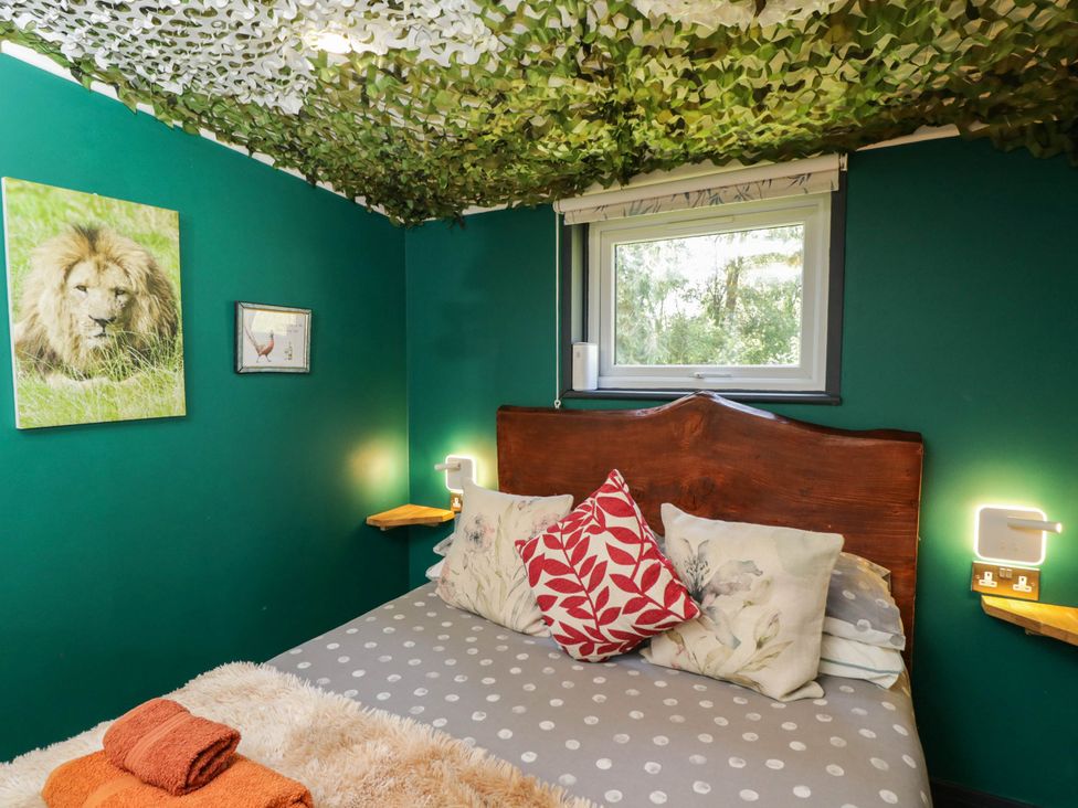 A bedroom with a bed and wall decor at Squirrels Lodge in South Molton
