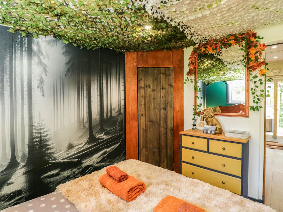 A bedroom with a bed and towels at Squirrels Lodge in South Molton