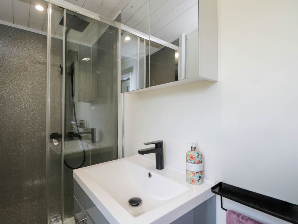 A bathroom with a sink and shower at Squirrels Lodge in South Molton