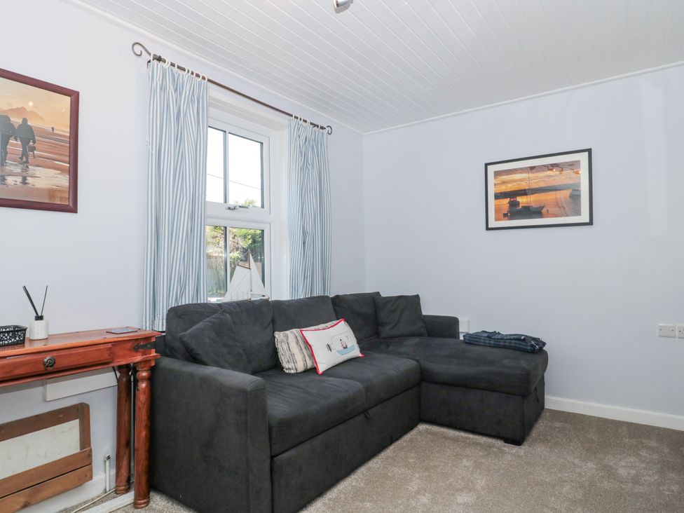 A living room with a sofa and a table at Stones Throw in Lymington