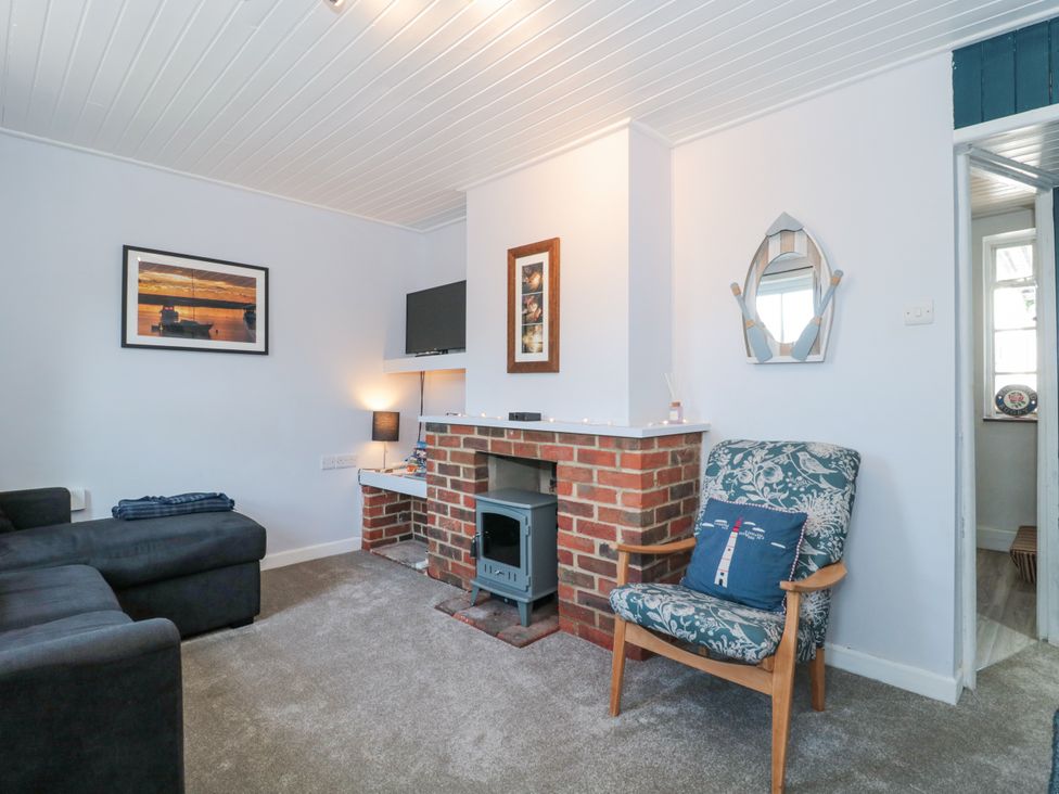 A living room with a fireplace and sofa at Stones Throw in Lymington