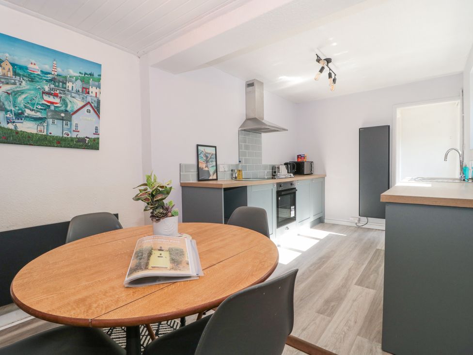 A kitchen with a dining table and chairs at Stones Throw Lymington