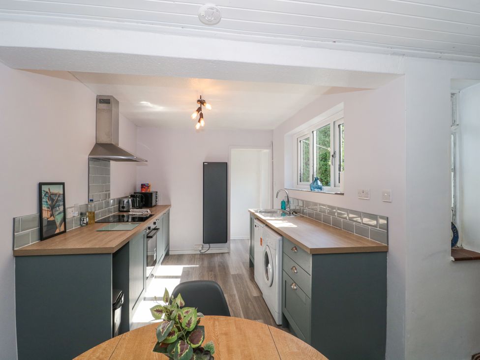 A kitchen with appliances and a table at Stones Throw in Lymington