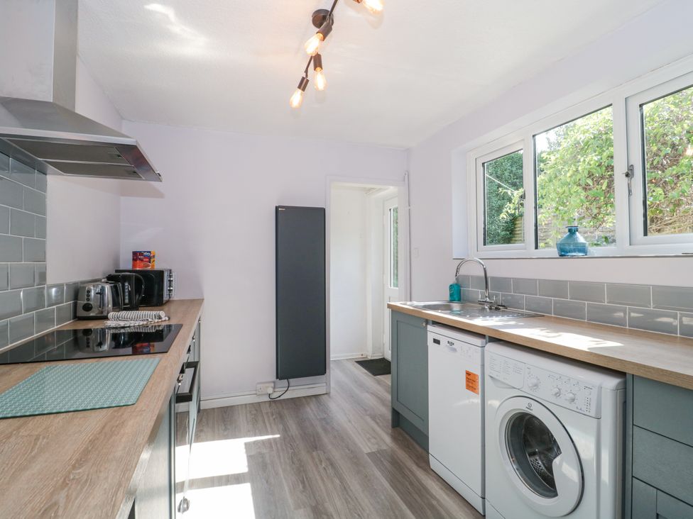A kitchen with washing machine and refrigerator at Stones Throw in Lymington