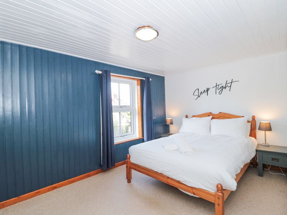 A bedroom with a bed and bedside table at Stones Throw in Lymington