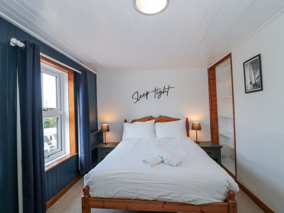 A bedroom with a bed and bedside table at Stones Throw in Lymington