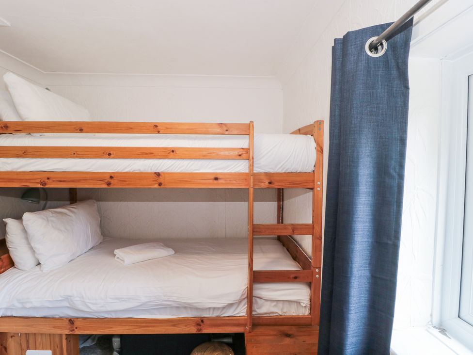 A bunk bed with linens in a bedroom at Stones Throw in Lymington