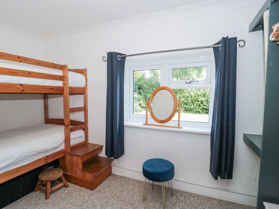 A bedroom with a bunk bed and a mirror at Stones Throw in Lymington