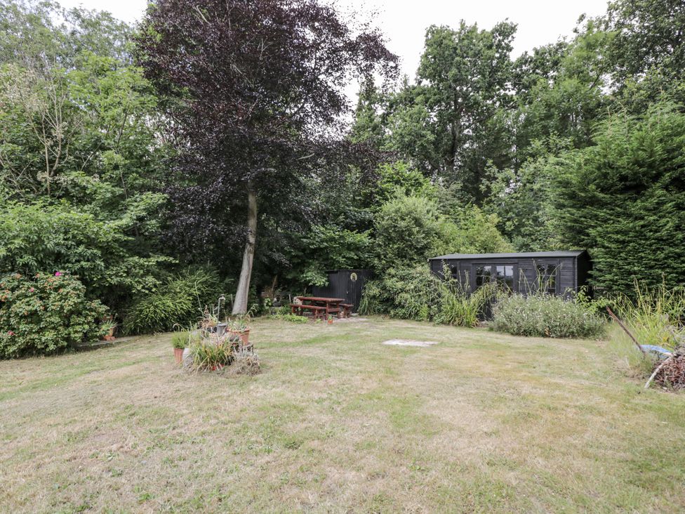 A garden with a picnic table and shed at Woods Cottage in Kingcoed near Raglan