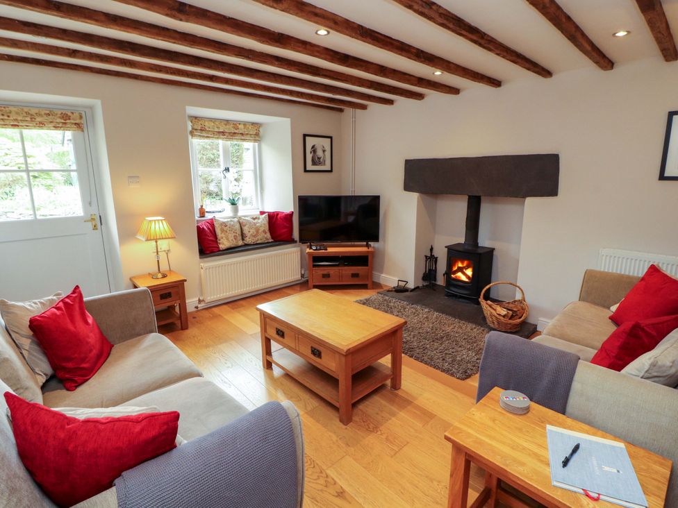 A living room with a sofa and stove at Byways in Ambleside