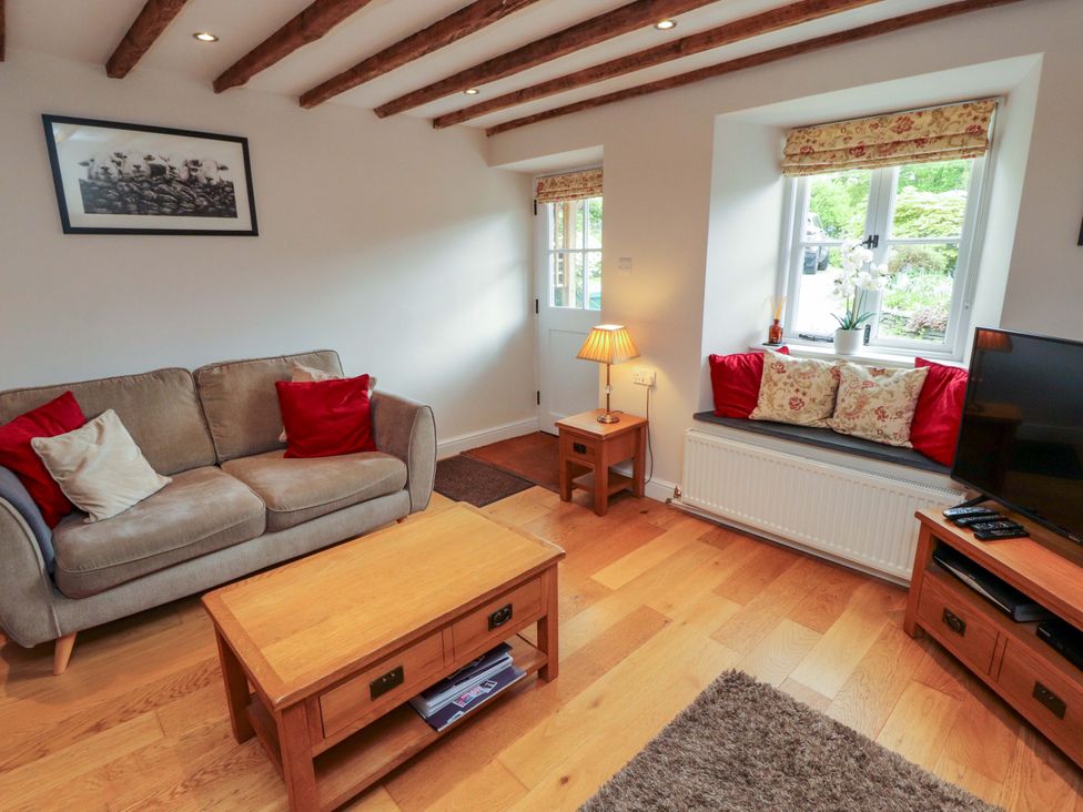 A living room with a sofa, coffee table, and TV at Byways in Ambleside
