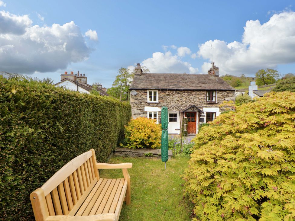 A garden with a bench and a house at Byways Ambleside