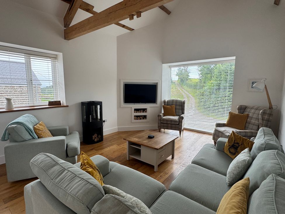 A living room with a television and seating area at Old Orchard Barn St Mellion near St Dominick