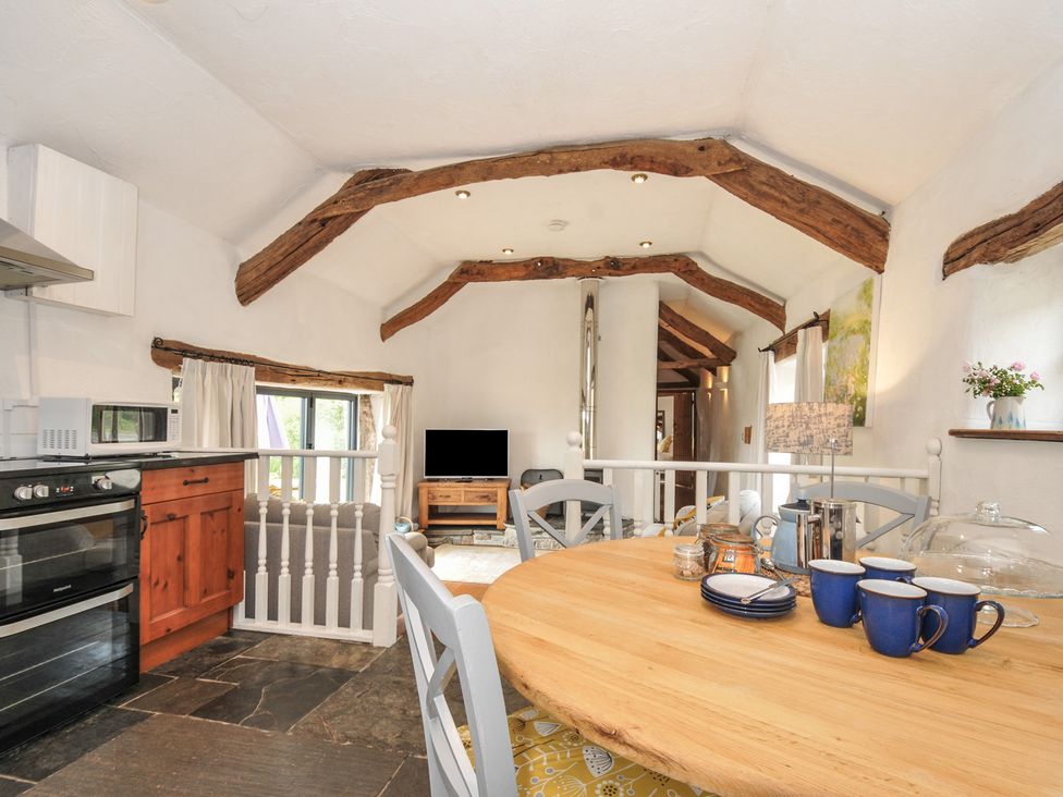 A kitchen with a dining table and television at Skiber Long Bray Shop near Launceston