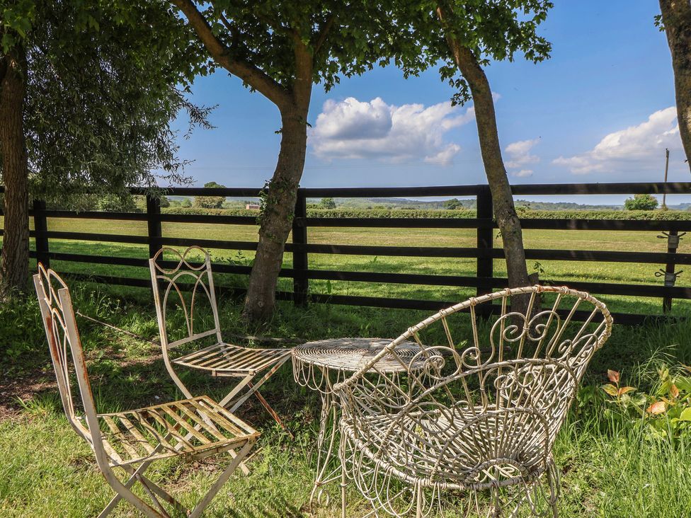 An outdoor seating area with a table and chairs at Low Grounds Cottage Harome near Helmsley