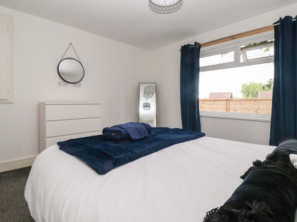 A bedroom with a bed and mirror at Fox Retreat Sherburn