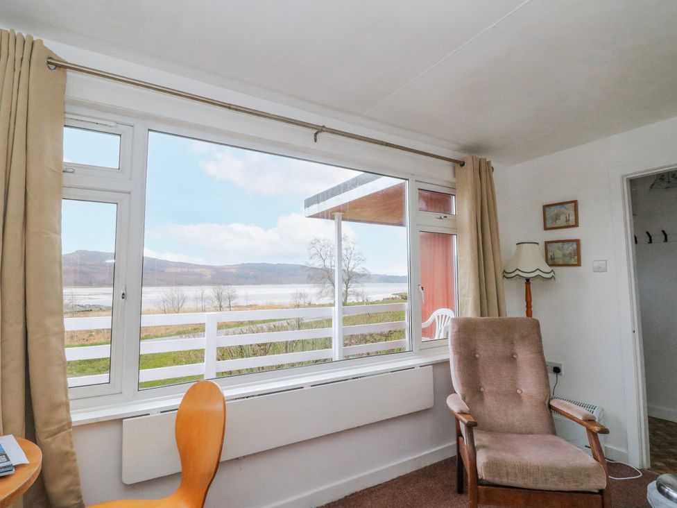A living room with a window and chair at Lochead Chalet near Lochgilphead
