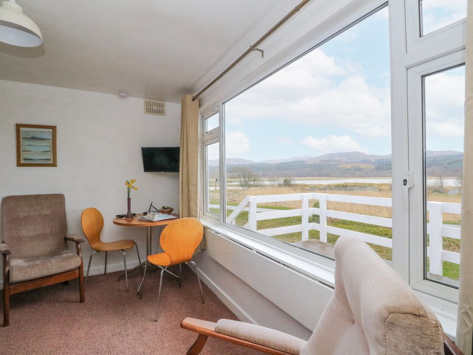 A living room with a table and chairs at Lochead Chalet Achahoish near Lochgilphead