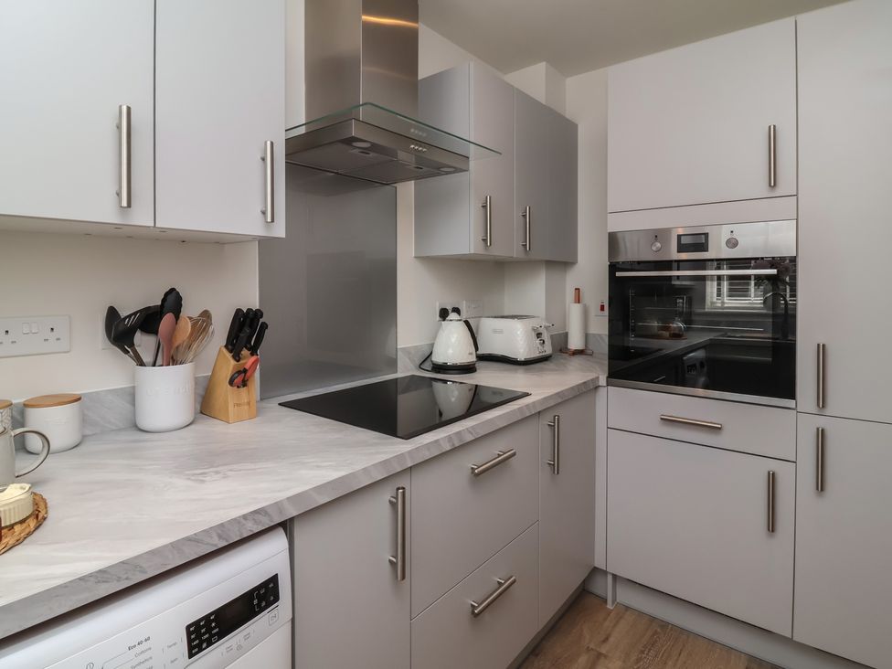A kitchen with cabinets and appliances at Seashell Sands in Appledore