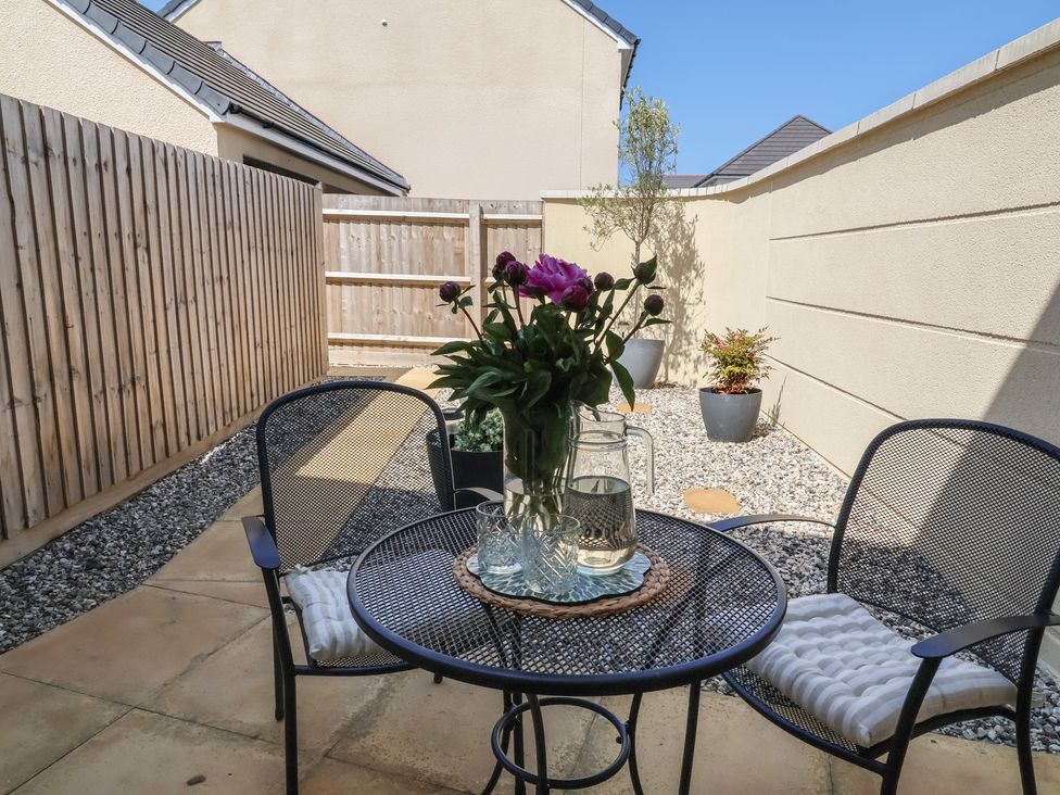 A garden with a table and chairs and flowers at Seashell Sands in Appledore