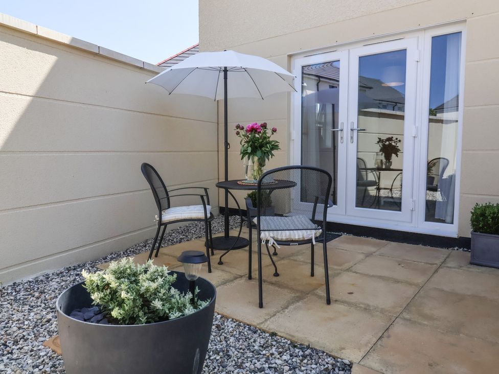 An outdoor patio with a table and chairs at Seashell Sands in Appledore